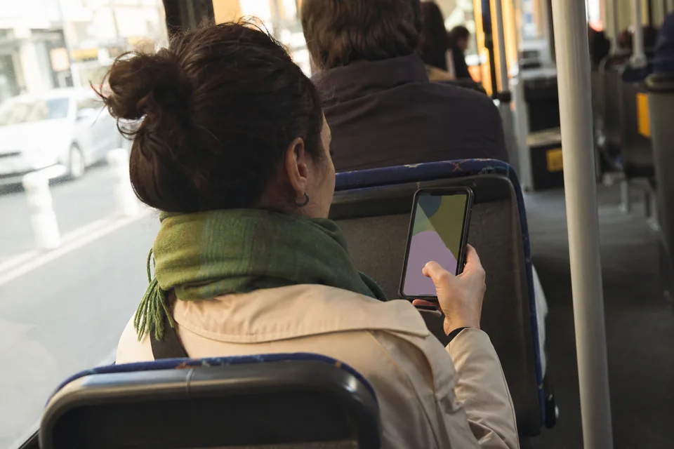 Klientka w tramwaju rezerwuje wizytę w telefonie przez stronę rezerwacji